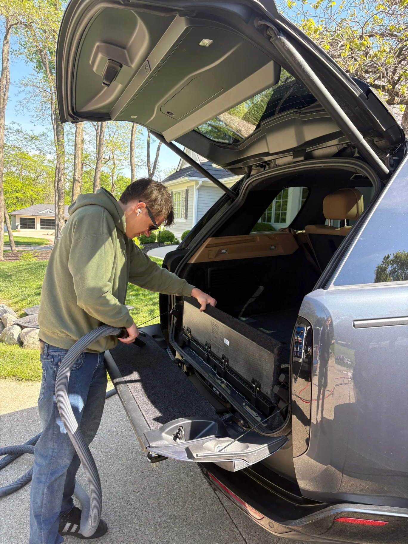 Technician steam vacuuming SUV rear