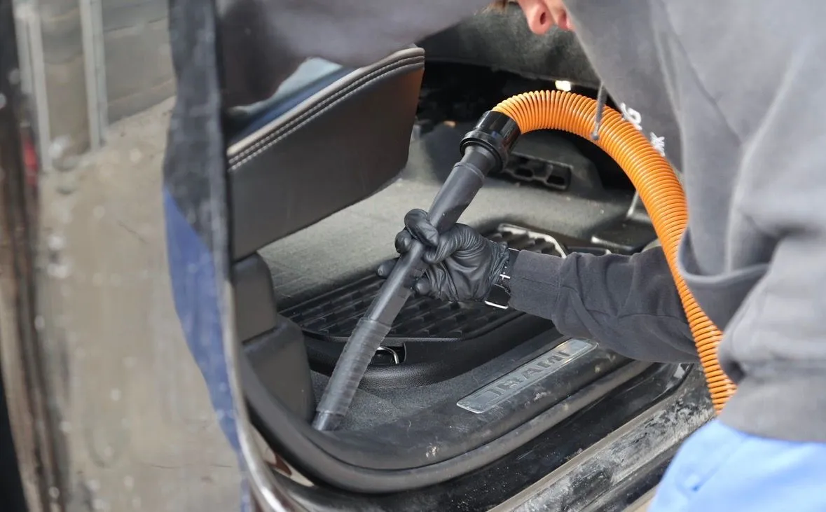 Detailer vacuuming truck footwell
